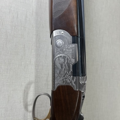 Espingarda Beretta em madeira e metal com detalhes decorativos.