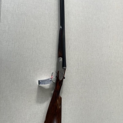 Espingarda de canos duplos com coronha de madeira e canos pretos pendurada