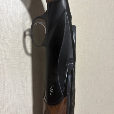 Espingarda com madeira castanha, corpo metálico preto e texto branco n828
