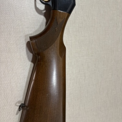 Espingarda com coronha em madeira castanha e área metálica preta com gravuras e texto GALLARD-12 GA.