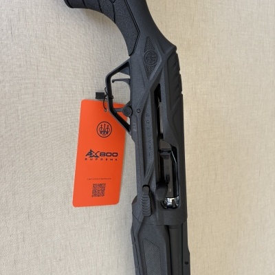 Espingarda preta BERETTA com etiqueta laranja AX800 SUPREMA e código QR