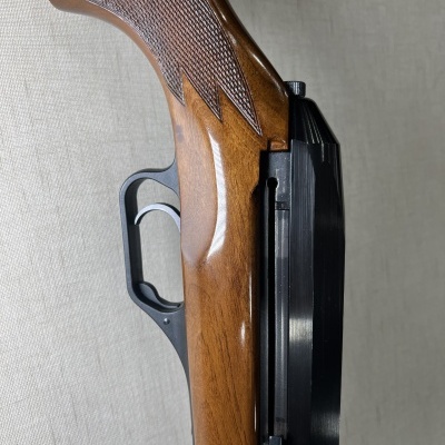 Espingarda com coronha em madeira castanha e cano metálico preto