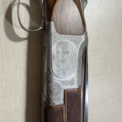 Espingarda com cabo de madeira e acabamento metálico decorado