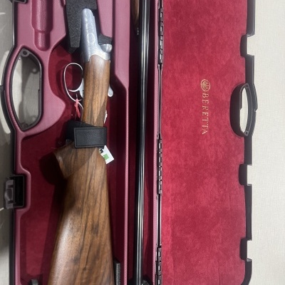 Espingarda desmontada dentro de estojo rígido vermelho com nome BERETTA