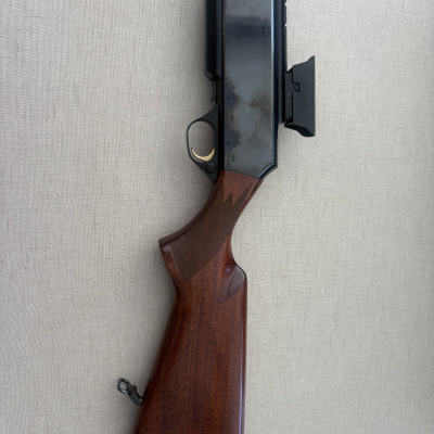 Arma de fogo com coronha de madeira castanha e corpo metálico preto com marcação BROWNING BAR II