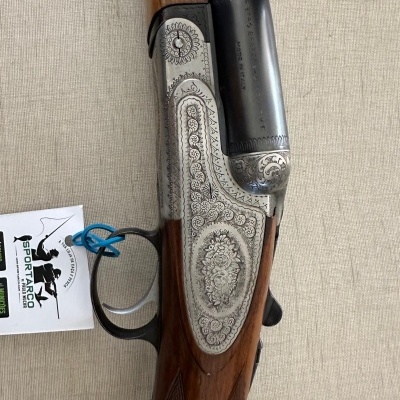 Espingarda de cano duplo com coronha de madeira e metal gravado, etiqueta Sportarno