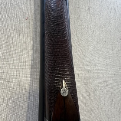 Espingarda de canos duplos com coronha em madeira trabalhada e peça metálica prateada