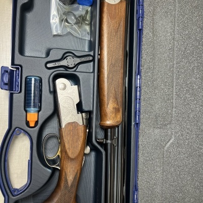 Espingarda desmontada em estojo azul com acessórios