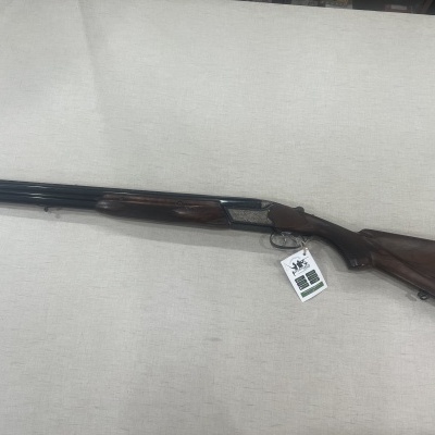 Espingarda de canos duplos com coronha de madeira escura e etiqueta pendurada