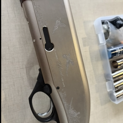 Arma de fogo prateada com cabo de madeira e caixa de acessórios metálicos