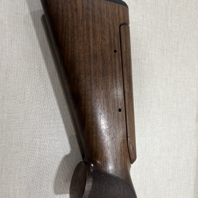 Cabo de espingarda em madeira castanha com punho texturizado e parte superior preta