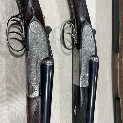 Dois rifles de cano duplo com coronhas de madeira e metal gravado