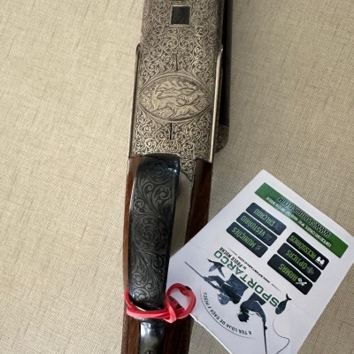 Espingarda decorada com etiqueta SPORT ARCO sobre tecido bege