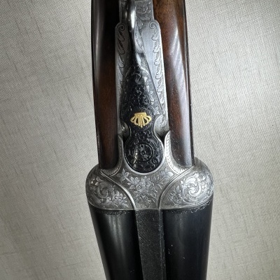 Espingarda de canos duplos em metal com gravações e cabo de madeira