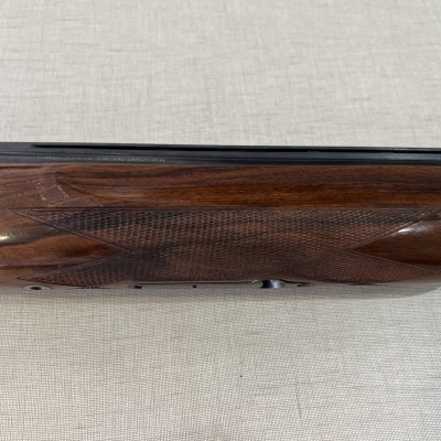 Coronha de espingarda em madeira castanha com textura entalhada