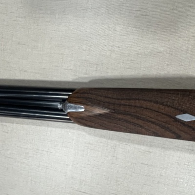 Espingarda com coronha de madeira escura e cano metálico negro