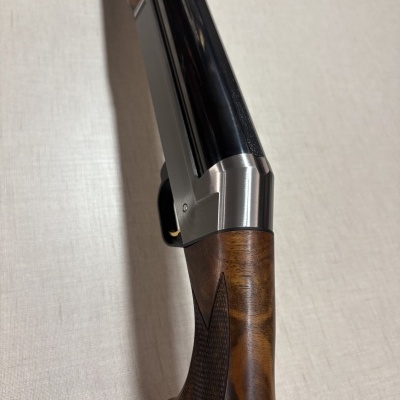 Espingarda com coronha de madeira e partes metálicas pretas e prateadas