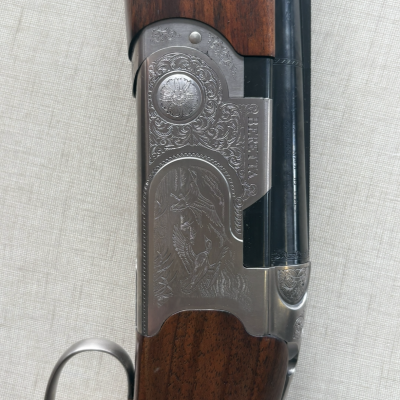 Espingarda Beretta com madeira castanha e detalhes gravados em metal prateado
