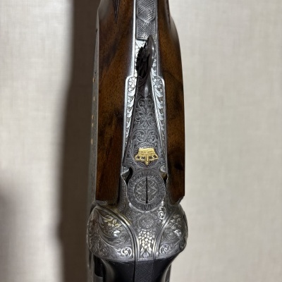 Vista superior de arma de fogo com madeira e metais gravados com detalhes dourados