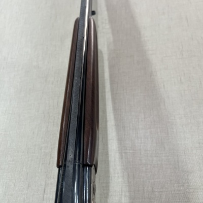 Espingarda vista de cima com madeira polida e metal escuro