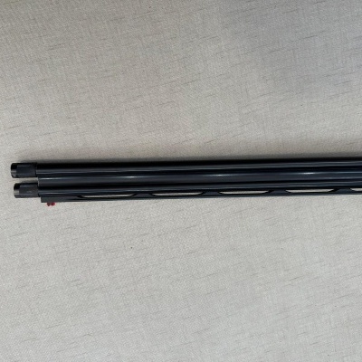 Três varas cilíndricas pretas paralelas sobre tecido bege