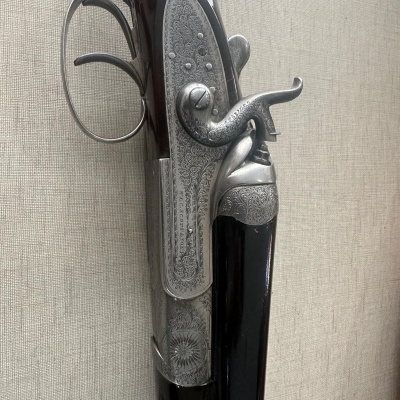 Espingarda com canos duplos e detalhes gravados