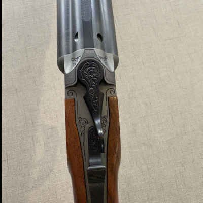 Espingarda com canos paralelos, madeira castanha e detalhes gravados