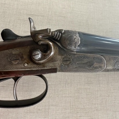 Arma de caça de cano duplo com madeira castanha e metal gravado