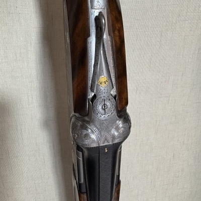 Espingarda com gravações ornamentais e detalhes metálicos