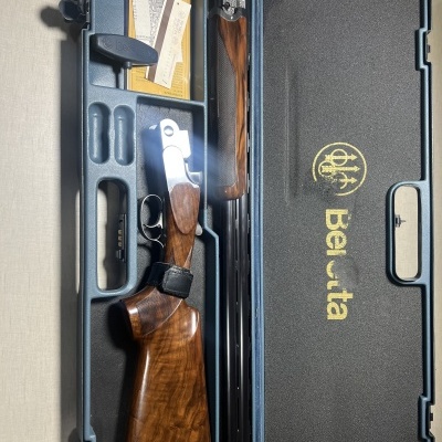 Estojo rígido com espingarda decomponível de madeira e metal no interior almofadado