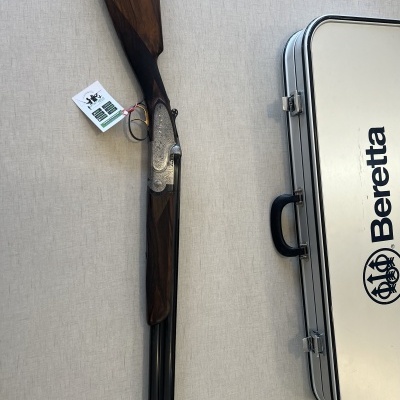 Espingarda Beretta com estojo branco ao lado