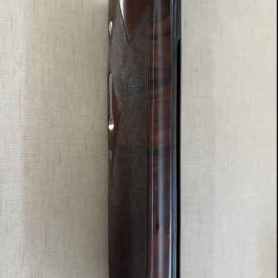 Coronha de madeira escura e cano metálico prateado de arma de fogo