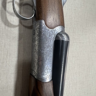 Espingarda com detalhes em metal prateado e madeira castanha