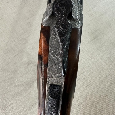 Parte superior de espingarda com madeira castanha e metal gravado