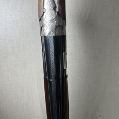 Espingarda de cano duplo com acabamento em madeira e metal prateado