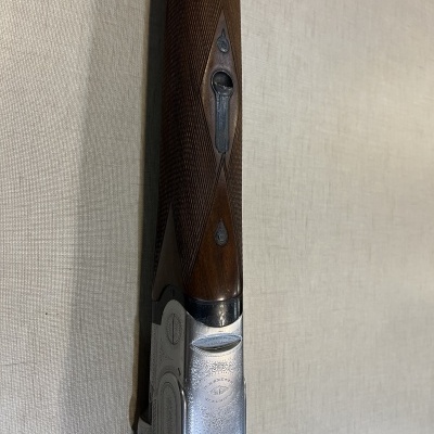 Espingarda com madeira castanha texturizada e metal prateado gravado