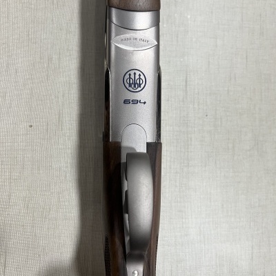 Espingarda de madeira e metal com inscrições e símbolo da marca Beretta