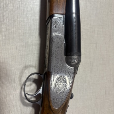 Espingarda caça madeira castanha detalhes metálicos gravados cano preto texto