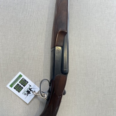 Espingarda de caça de madeira e metal sobre superfície clara