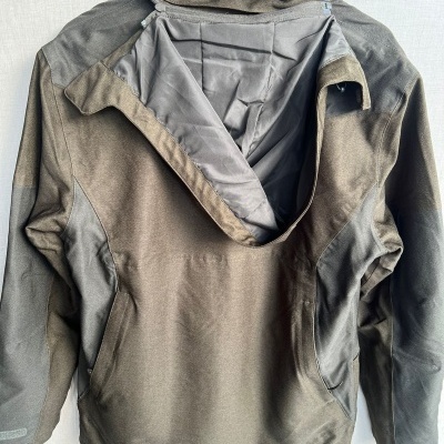 Casaco desportivo cinza e verde-oliva com forro interior cinzento e fechos na parte de trás e mangas