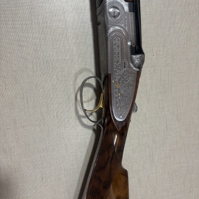 Carabina com madeira castanha e detalhes gravados em metal prateado