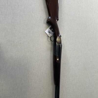 Espingarda com coronha em madeira castanha e cano duplo preto