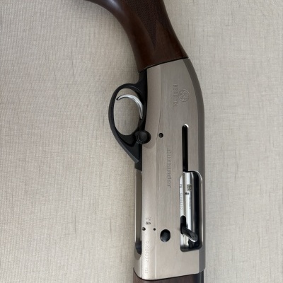 Espingarda de madeira castanha e metal prateado com inscrições BERETTA e DUOBAND