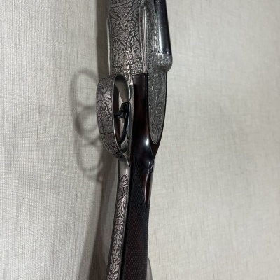 Espingarda de canos duplos com detalhes gravados e madeira escura