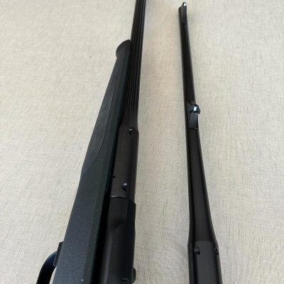 Espingarda de cano duplo com acabamento preto fosco sobre superfície clara