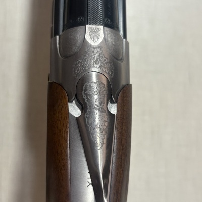 Arma de fogo com cabo em madeira e metal gravado com padrões florais