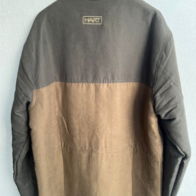 Casaco bicolor castanho escuro e bege com texto HART nas costas