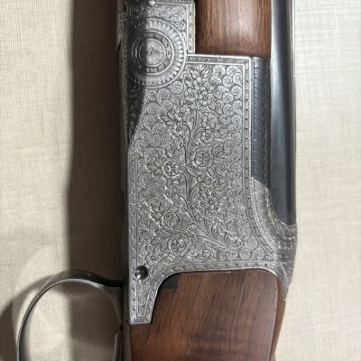 Espingarda com detalhes em madeira e metal gravado