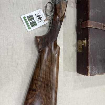 Espingarda de caça com coronha em madeira polida e issojo de couro castanho