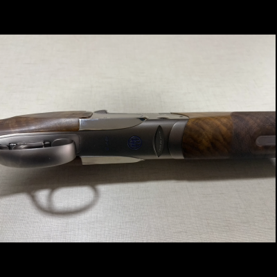 espingarda com estrutura metálica preta e coronha em madeira castanha